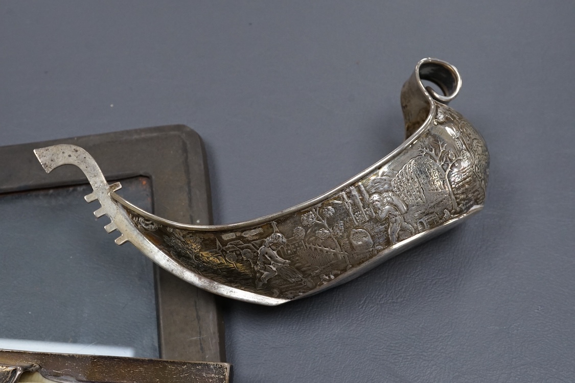 A 1940's silver mounted cigarette box, two small silver dishes, a silver mounted desk calendar, a silver mounted photograph frame and a continental silver bonbon dish modelled as a boat, import marks for John George Pidd